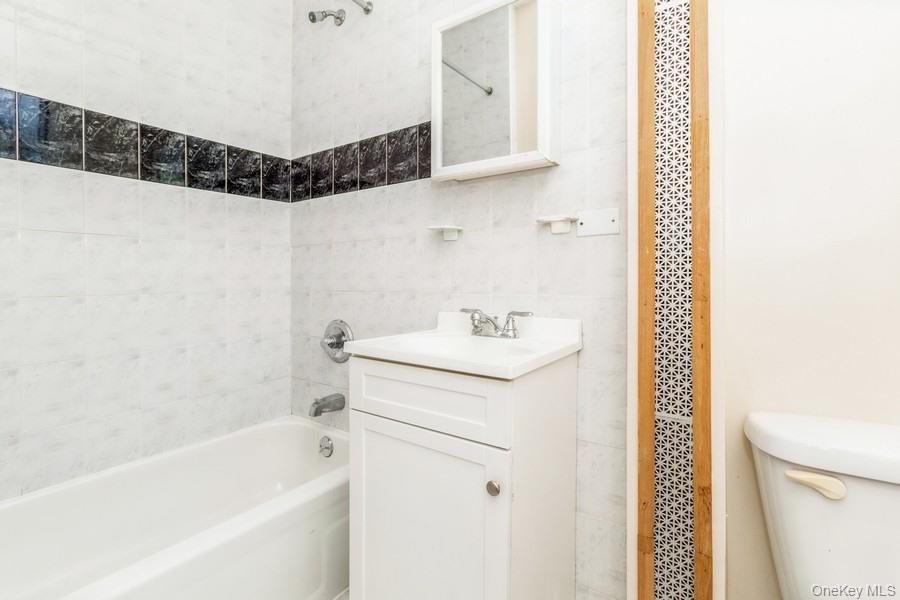 41-32 53rd Street Queens, NY 11377 - Photo 14 of 24 a bathroom with a sink a toilet and shower