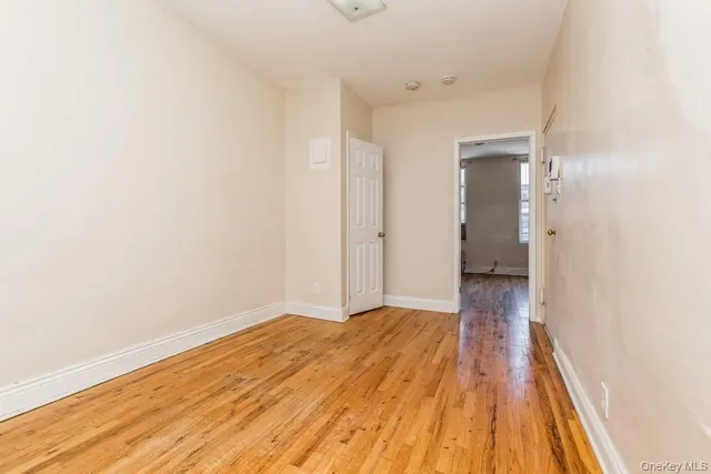 a view of a room with wooden floor and a ceiling fan