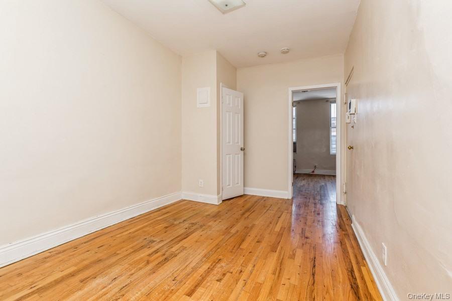 41-32 53rd Street Queens, NY 11377 - Photo 18 of 24 a view of a room with wooden floor and a ceiling fan