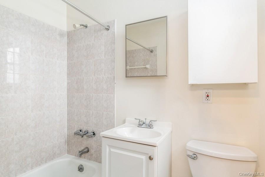 41-32 53rd Street Queens, NY 11377 - Photo 3 of 24 a bathroom with a sink a toilet and shower