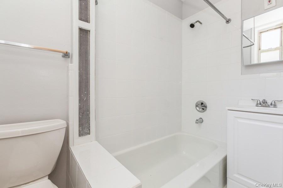 41-32 53rd Street Queens, NY 11377 - Photo 7 of 24 a white bath tub sitting next to a white toilet and vanity