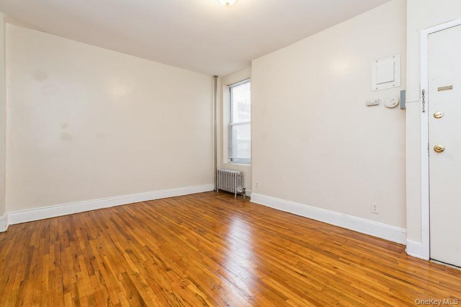 41-32 53rd Street Queens, NY 11377 - Photo 8 of 24 a view of an empty room with wooden floor and a window