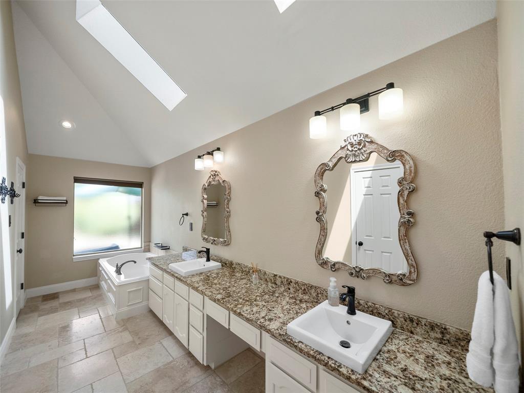 2516 Pepper Tree Circle McKinney, TX 75072 - Photo 26 of 40 Primary Bathroom that is beautiful and updated. Two sinks, separate large bathtub, granite countertops and tons of counter space. TWO walking closets and separate shower...Spa like ensuite bathroom.