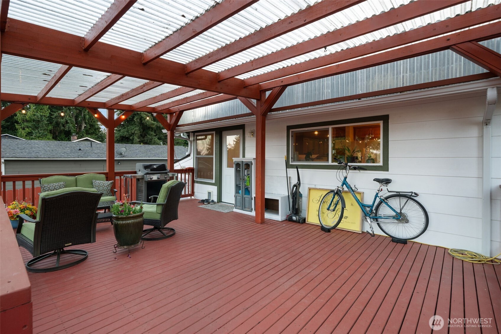 5026 Chico Way Northwest Bremerton, WA 98312 - Photo 22 of 36 a view of a roof deck with table and chairs under wooden roof with potted plants