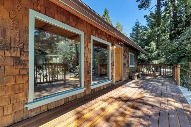 a view of backyard with large windows and plants