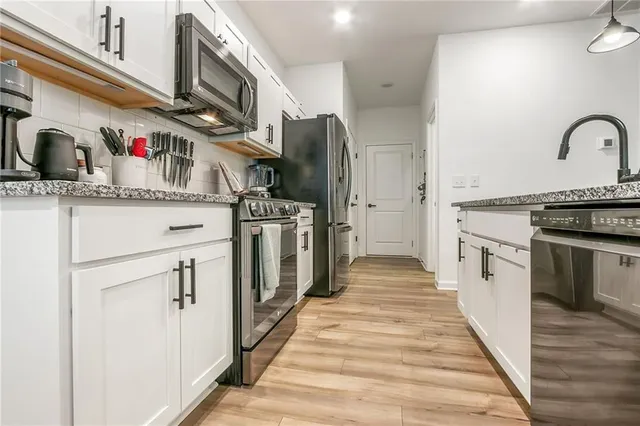 a kitchen with stainless steel appliances granite countertop a stove and a refrigerator