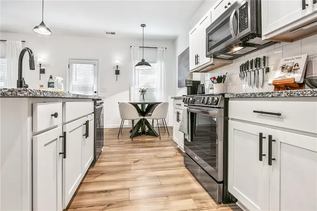 a kitchen with stainless steel appliances granite countertop a stove and a refrigerator