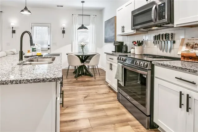 a kitchen with stainless steel appliances granite countertop a stove and a sink