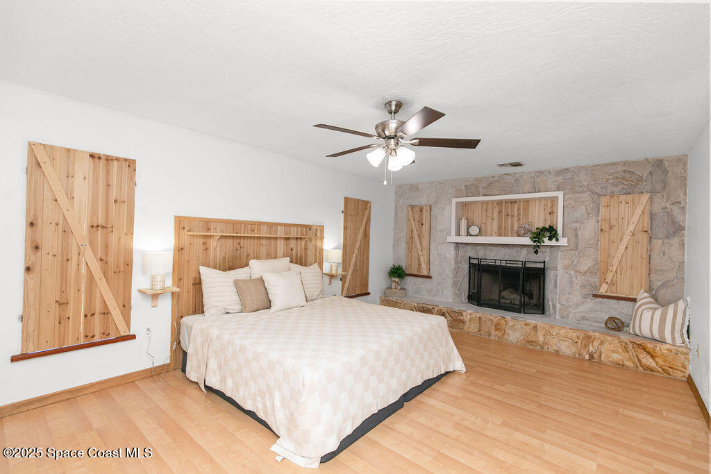2524 Trotters Trail Cocoa, FL 32926 - Photo 25 of 46 a spacious bedroom with a large bed and a fireplace
