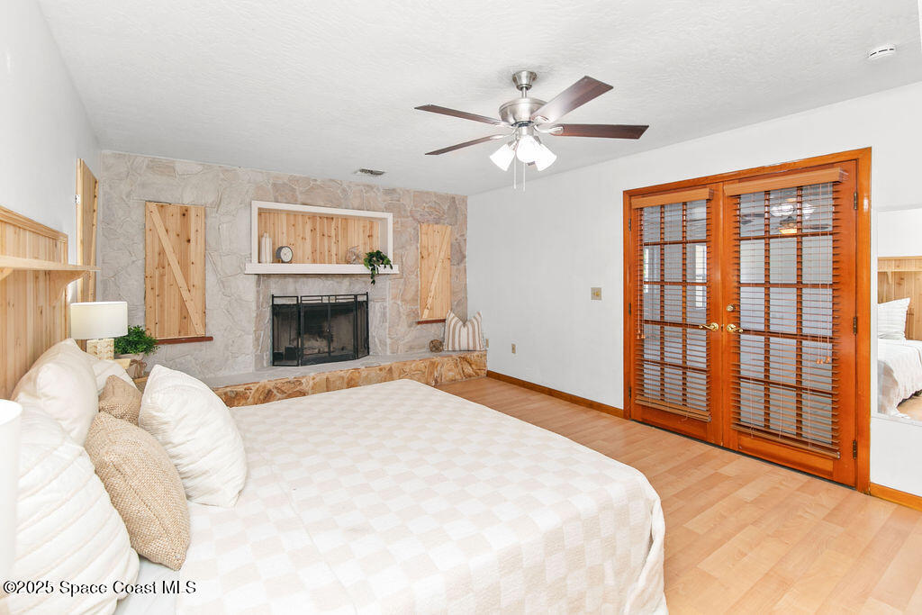 2524 Trotters Trail Cocoa, FL 32926 - Photo 26 of 46 a bedroom with a large bed and a fireplace
