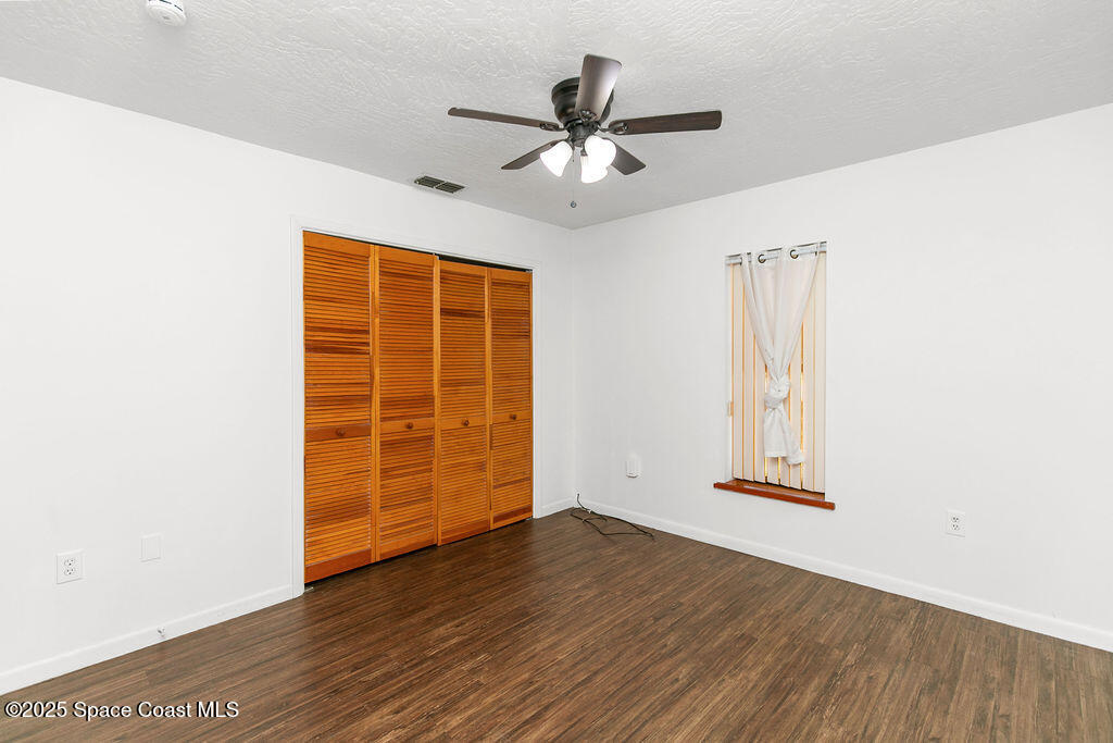 2524 Trotters Trail Cocoa, FL 32926 - Photo 28 of 46 an empty room with wooden floor cabinet and windows