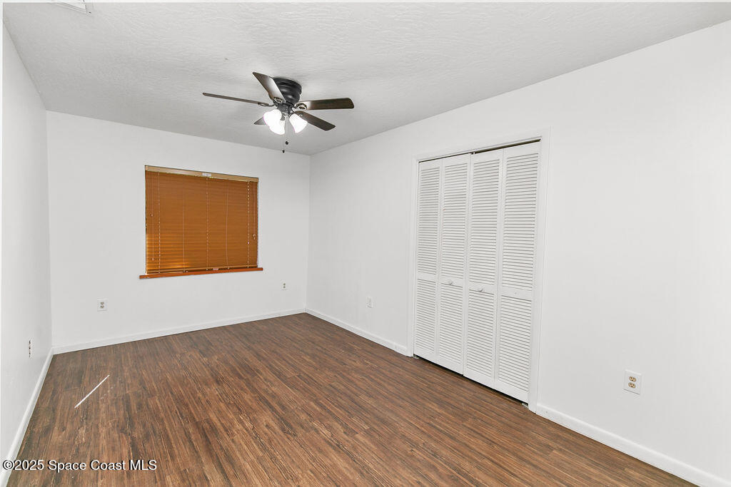 2524 Trotters Trail Cocoa, FL 32926 - Photo 29 of 46 a view of an empty room with wooden floor and a ceiling fan