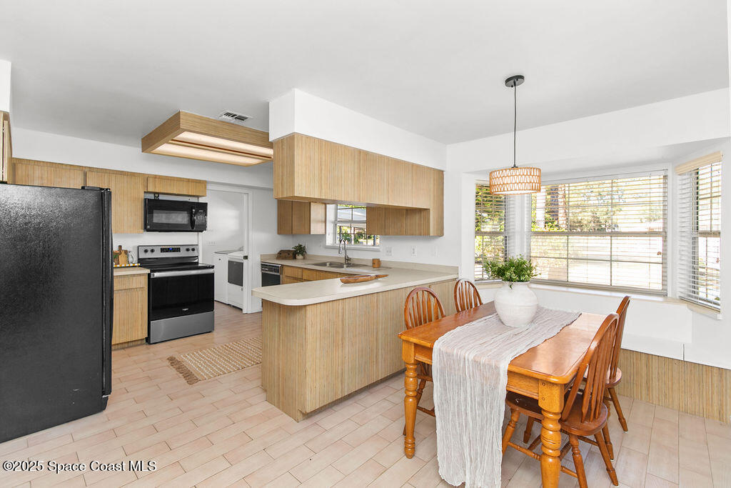 2524 Trotters Trail Cocoa, FL 32926 - Photo 4 of 46 a kitchen with stainless steel appliances granite countertop a stove a sink a microwave a dining table and chairs