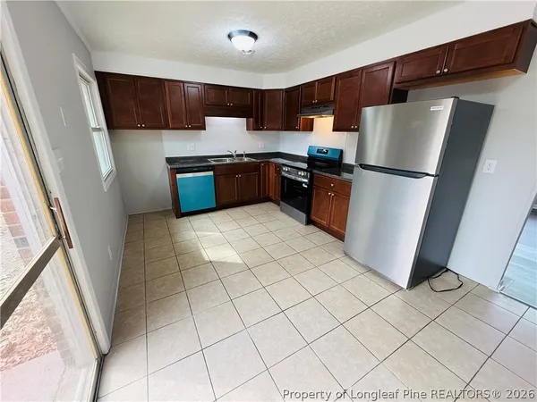 a kitchen with stainless steel appliances granite countertop a refrigerator sink and cabinets