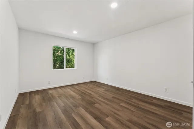 an empty room with wooden floor and a window