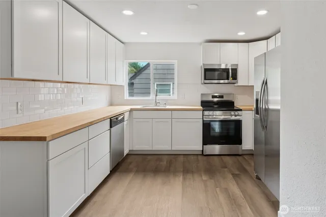 a kitchen with stainless steel appliances granite countertop a sink and a stove top oven