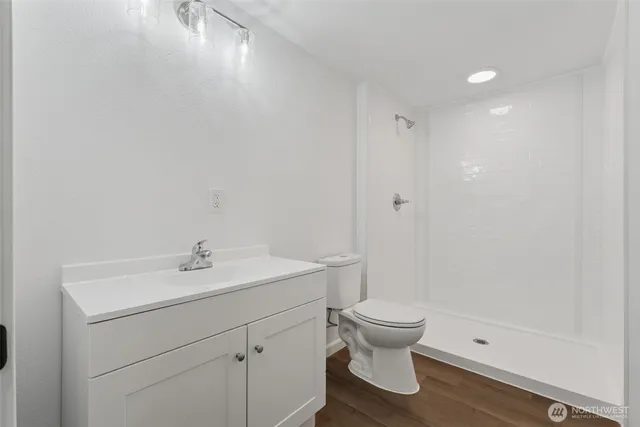 a bathroom with a sink a toilet and shower