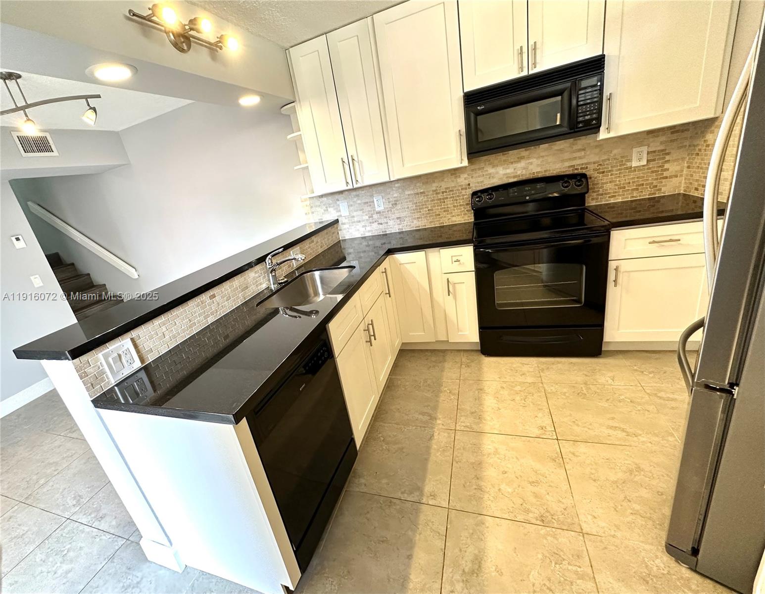 a kitchen with a sink and a stove top oven