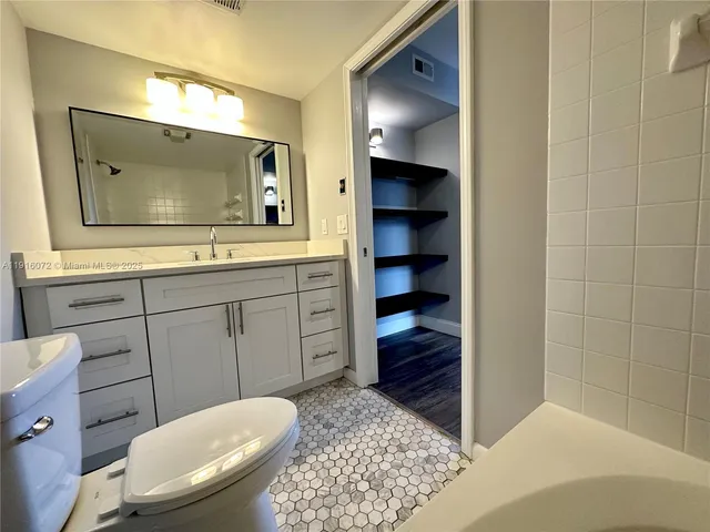 a bathroom with a toilet a sink and mirror