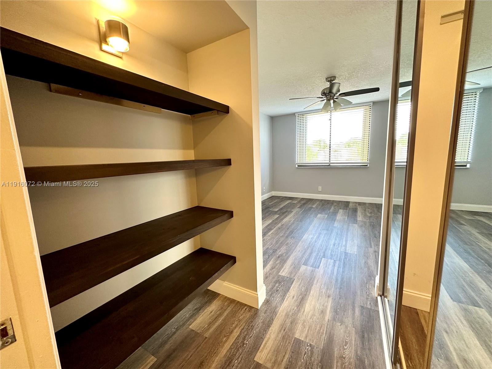 22970 Oxford Place, Unit A Boca Raton, FL 33433 - Photo 16 of 24 a view of walk in closet with wooden floor