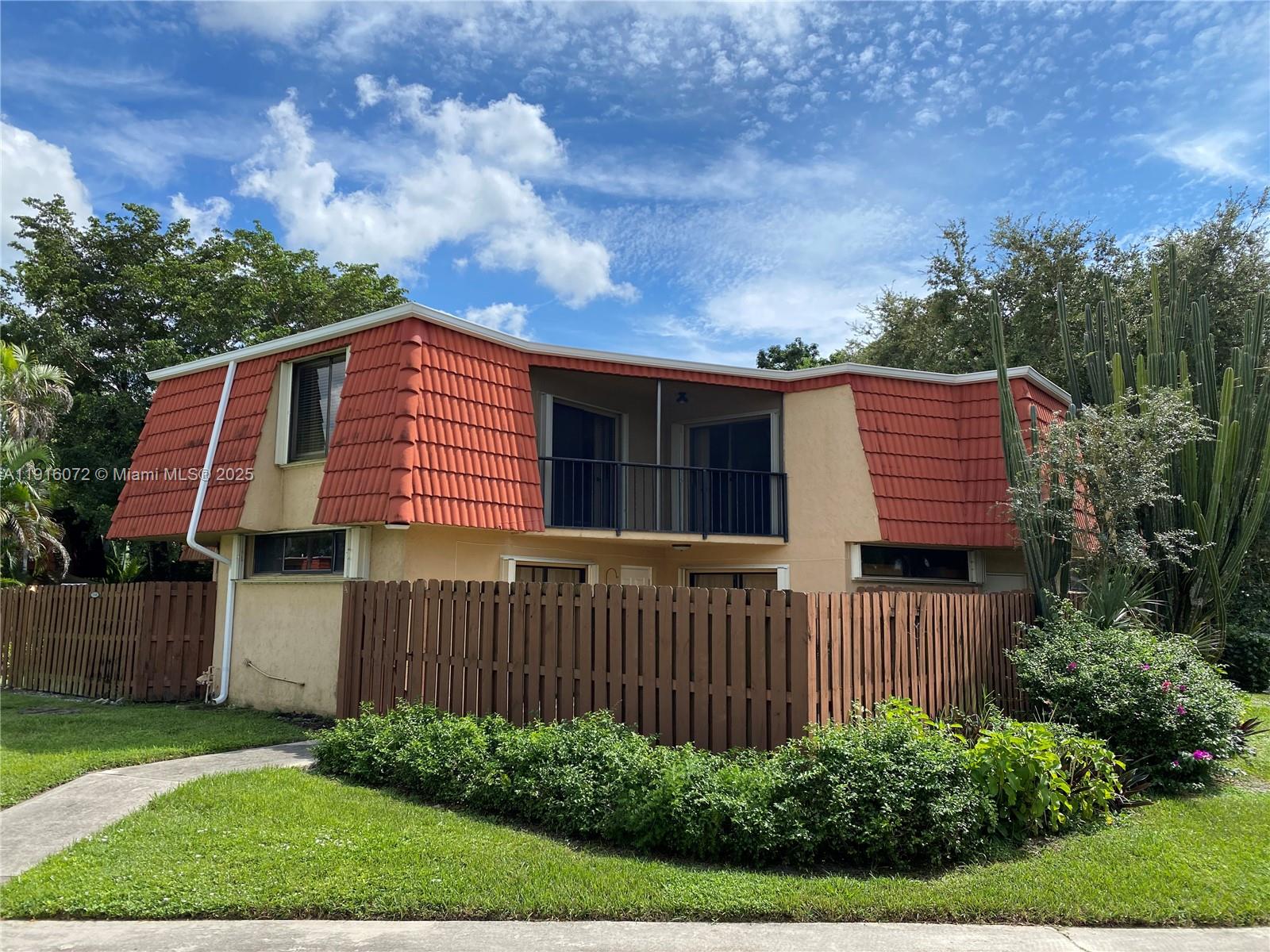 22970 Oxford Place, Unit A Boca Raton, FL 33433 - Photo 20 of 24 a front view of a house with a garden