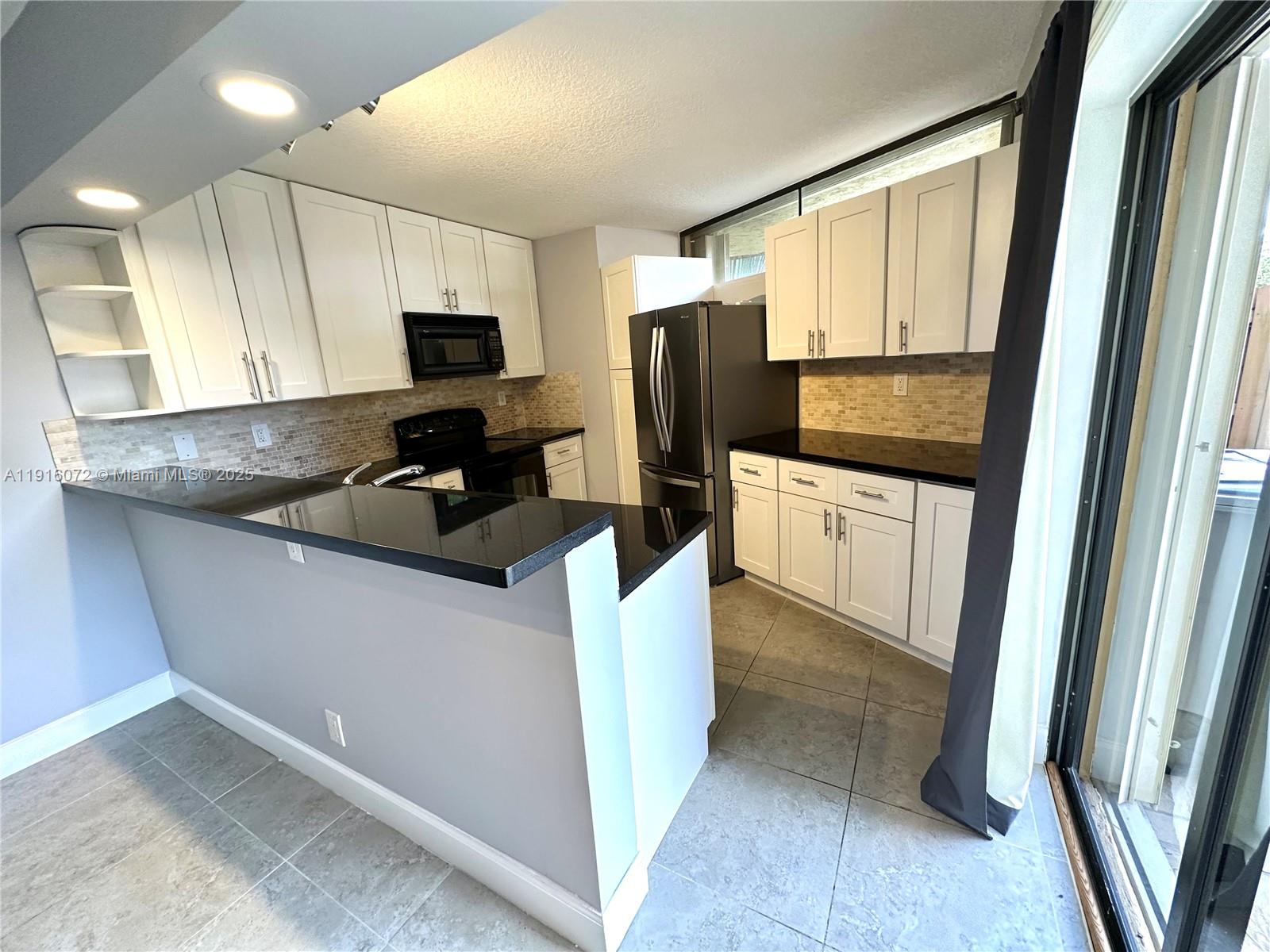 22970 Oxford Place, Unit A Boca Raton, FL 33433 - Photo 2 of 24 a kitchen with stainless steel appliances a refrigerator a sink a stove a microwave a counter space and cabinets