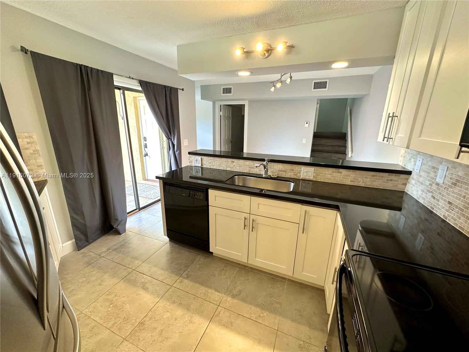 22970 Oxford Place, Unit A Boca Raton, FL 33433 - Photo 4 of 24 a kitchen with a sink refrigerator and window