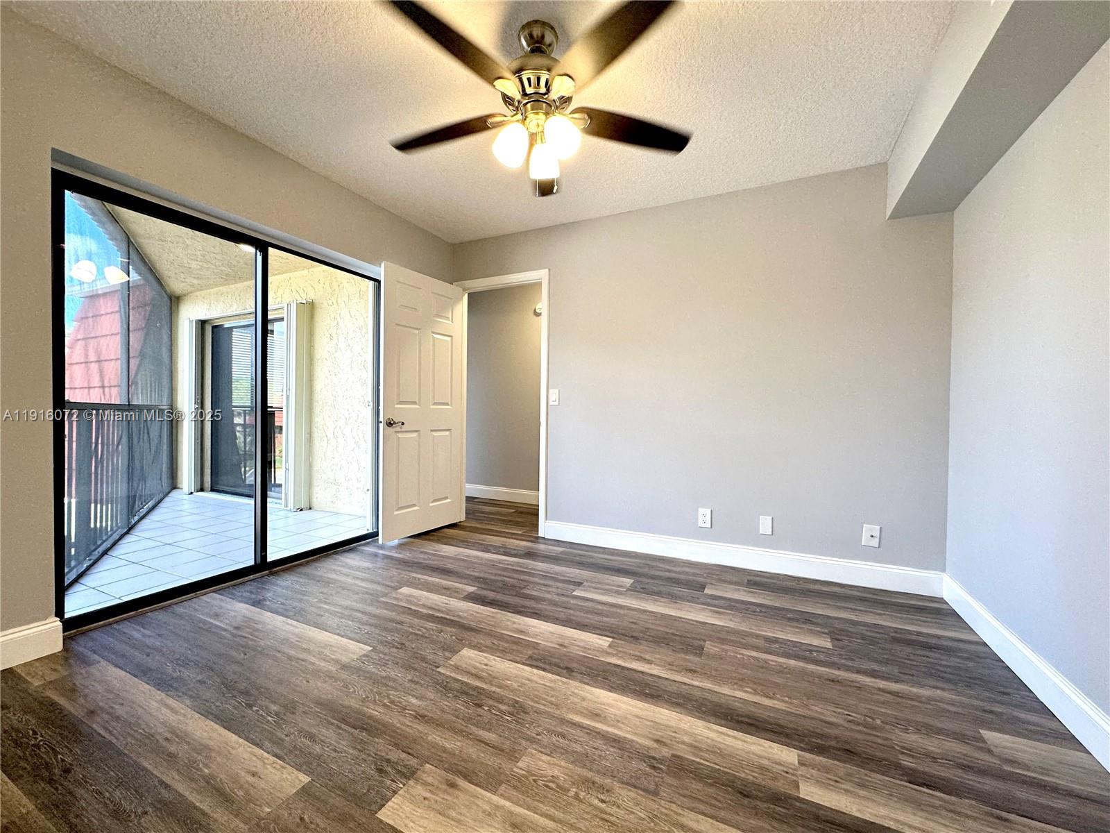 22970 Oxford Place, Unit A Boca Raton, FL 33433 - Photo 5 of 24 a view of an empty room with window and a ceiling fan