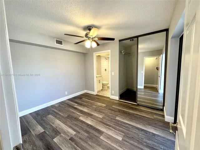 a view of a room with a ceiling fan and wooden floor
