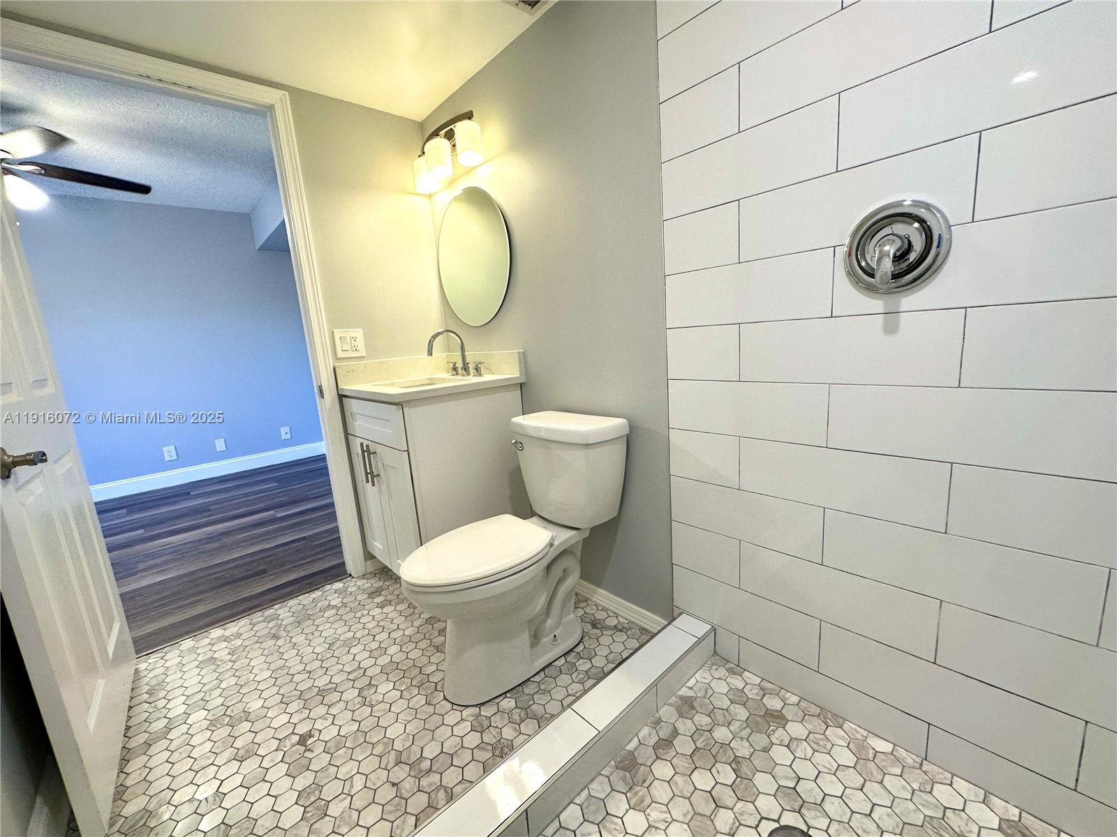 22970 Oxford Place, Unit A Boca Raton, FL 33433 - Photo 7 of 24 a bathroom with a toilet and a shower