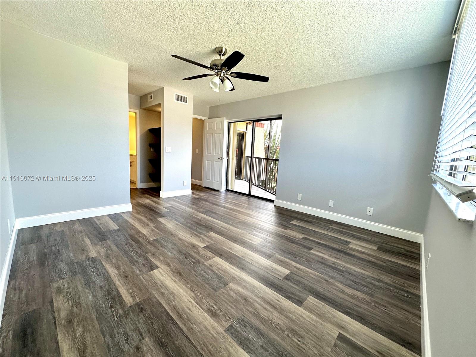 22970 Oxford Place, Unit A Boca Raton, FL 33433 - Photo 9 of 24 wooden floor in an empty room with a window
