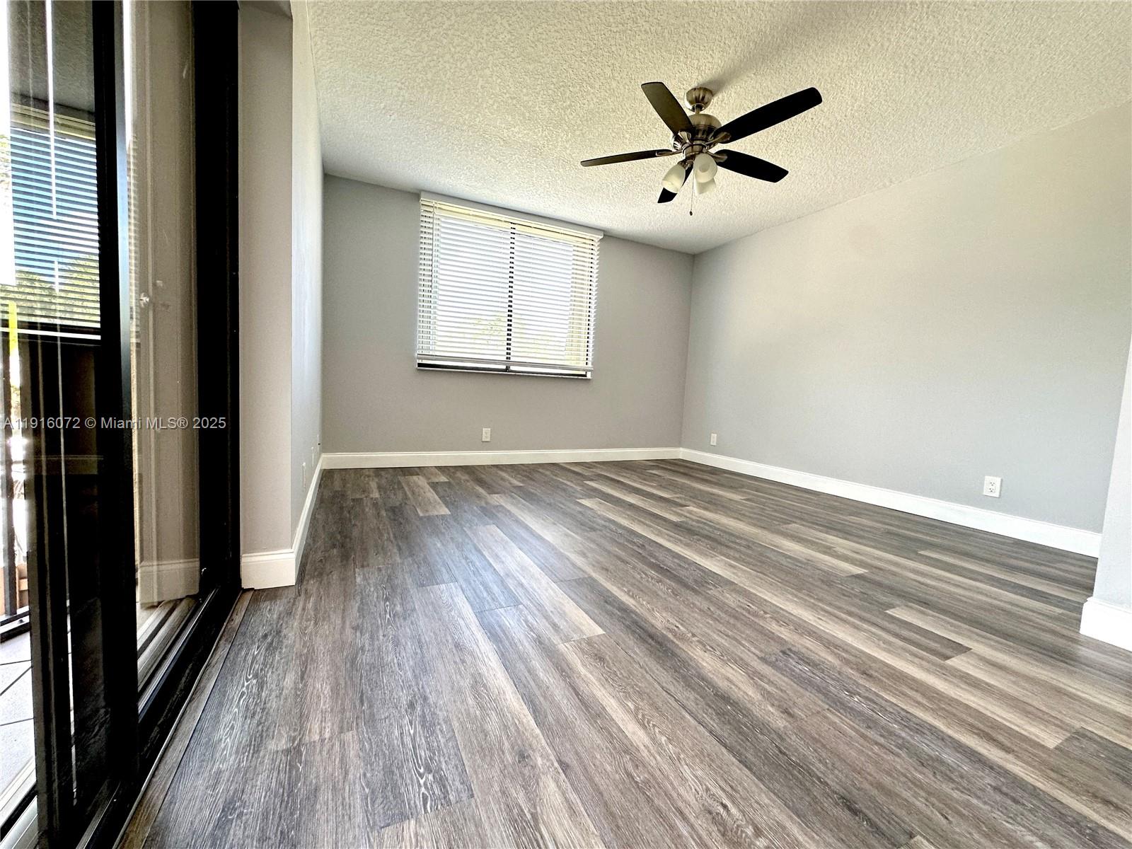 22970 Oxford Place, Unit A Boca Raton, FL 33433 - Photo 10 of 24 wooden floor in an empty room with a window