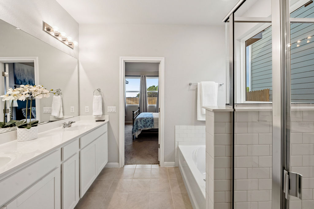 2417 Roosevelt Road Leander, TX 78641 - Photo 17 of 40 Full bathroom featuring connected bathroom, a shower stall, double vanity, and a garden tub