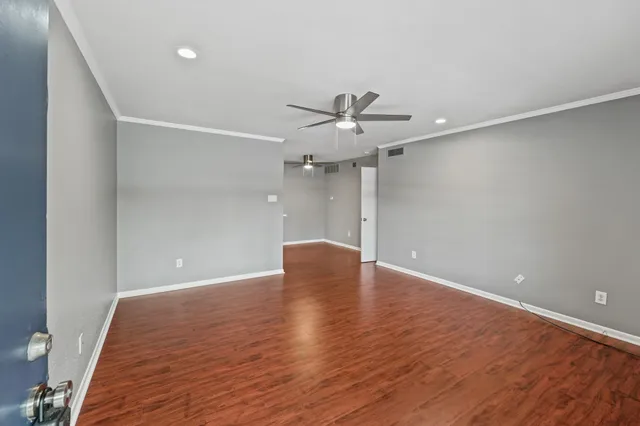 a view of an empty room with wooden floor