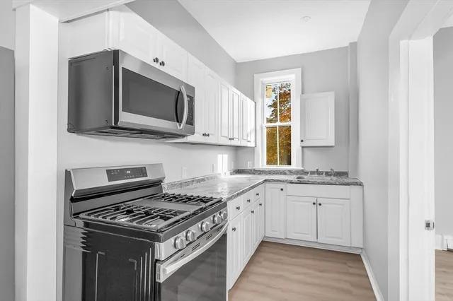 a kitchen with stainless steel appliances a stove microwave and sink
