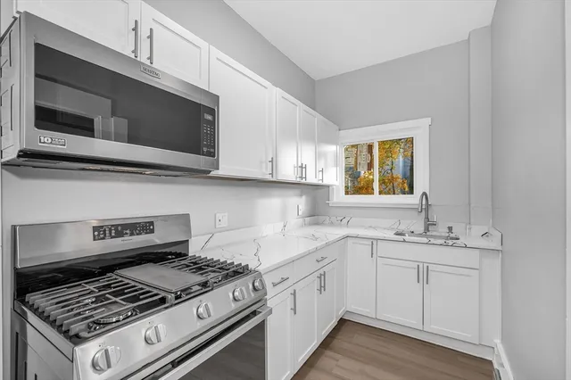 a kitchen with stainless steel appliances a sink a stove and microwave