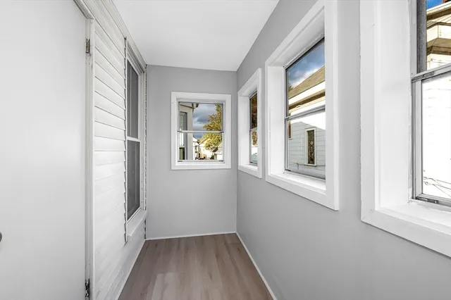 a view of hallway with windows and wooden floor