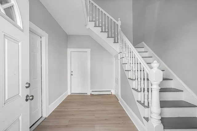 a view of staircase with wooden floor and white walls