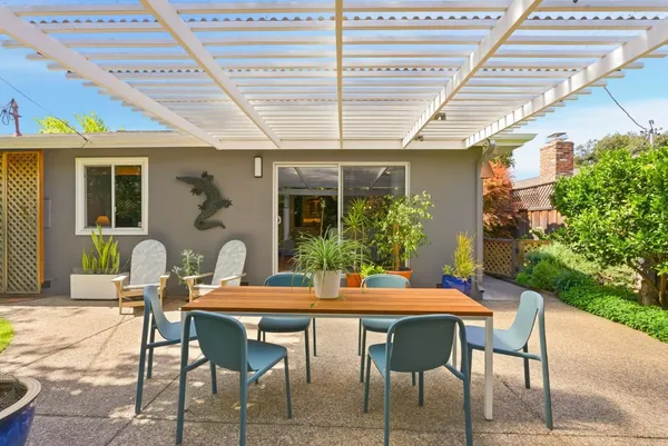 a front view of a house with outdoor seating and a potted plant