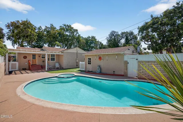 a view of a house with pool and chairs