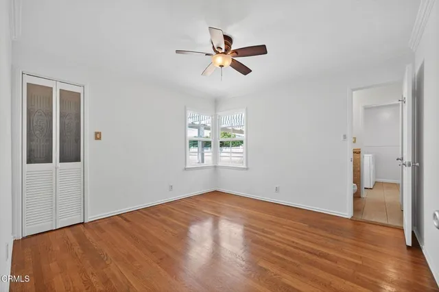 a view of a walk in closet with wooden floor