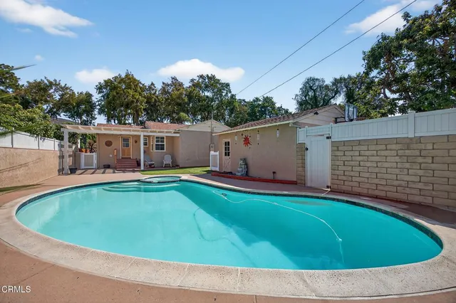 a view of a house with backyard and a tree