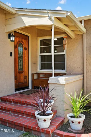 a view of front door of house with potted plants