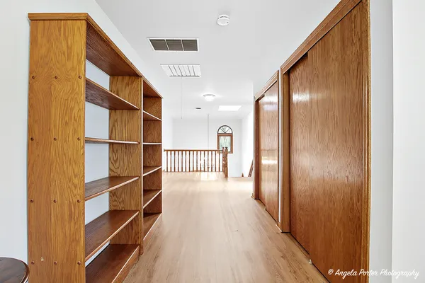 a view of a hallway with wooden floor and windows