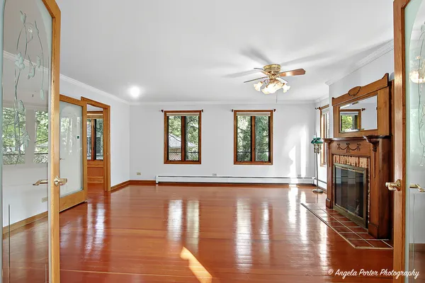 a view of an empty room with window and wooden floor