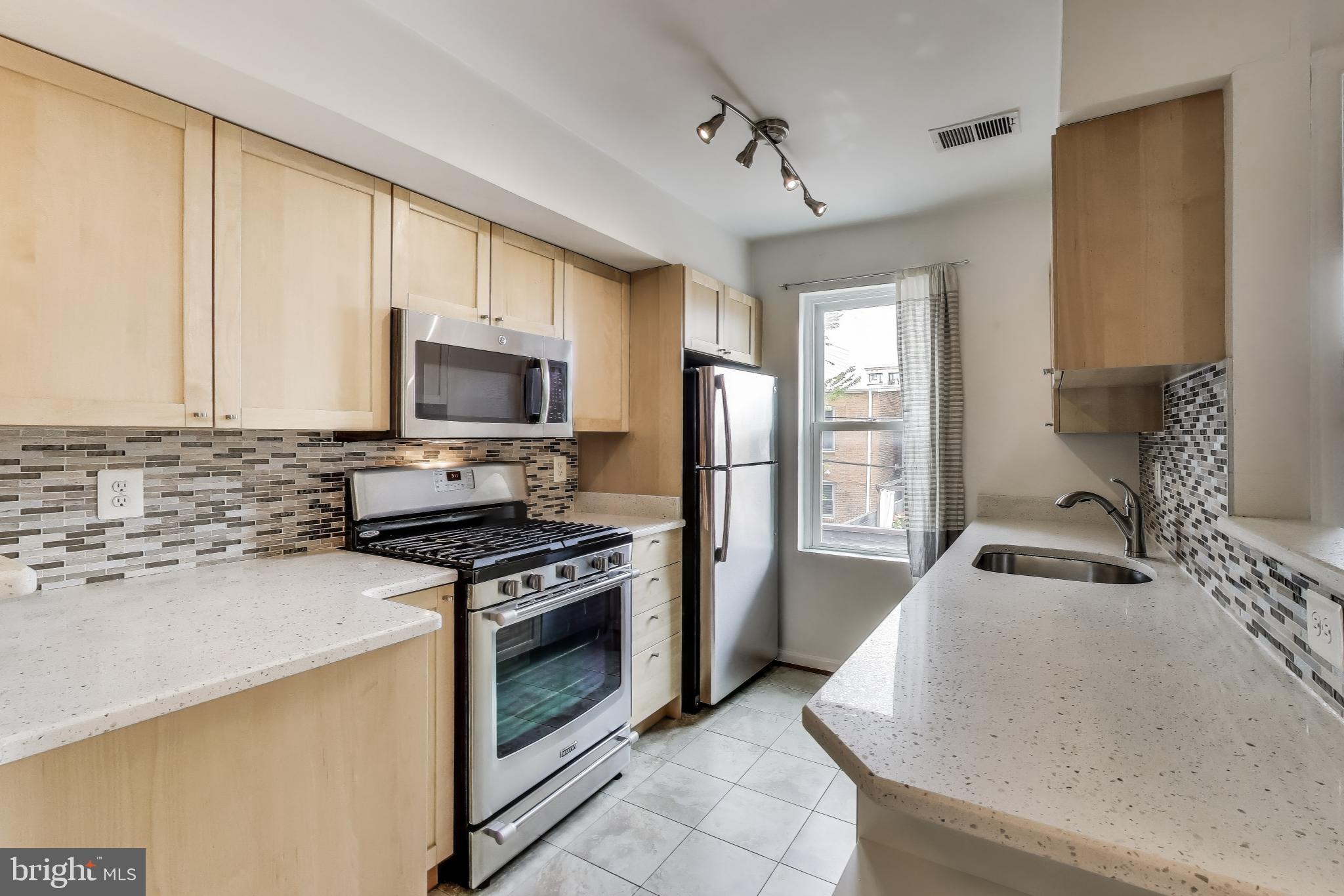 763 3rd Street Northeast Washington, DC 20002 - Photo 6 of 32 a kitchen with granite countertop a sink stainless steel appliances and cabinets