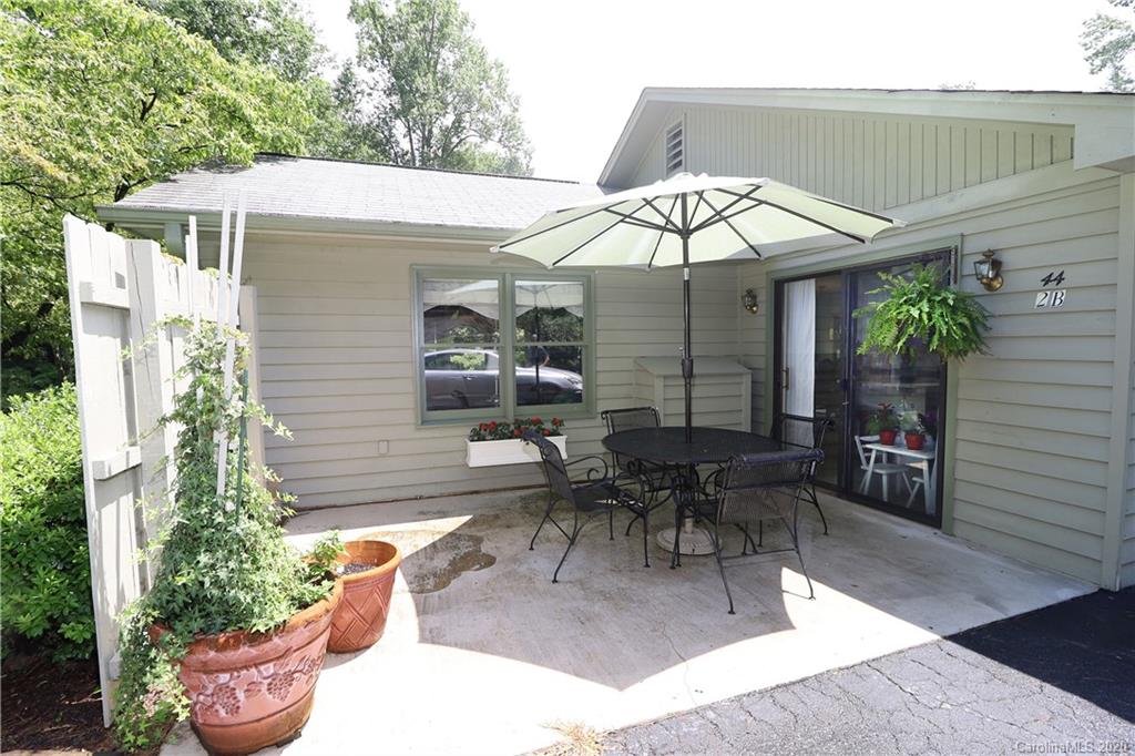 44 Jervey Road, Unit 2B Tryon, NC 28782 - Photo 3 of 24 a view of a patio with a table and chairs under an umbrella