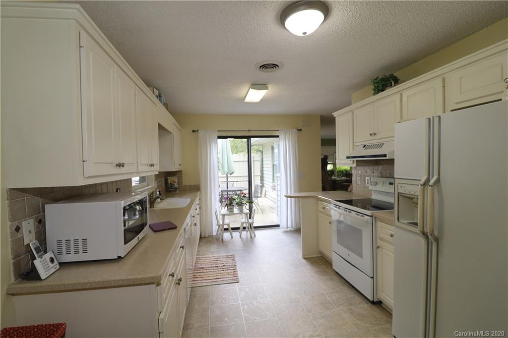 44 Jervey Road, Unit 2B Tryon, NC 28782 - Photo 4 of 24 a kitchen with granite countertop a sink a counter top space stainless steel appliances and cabinets