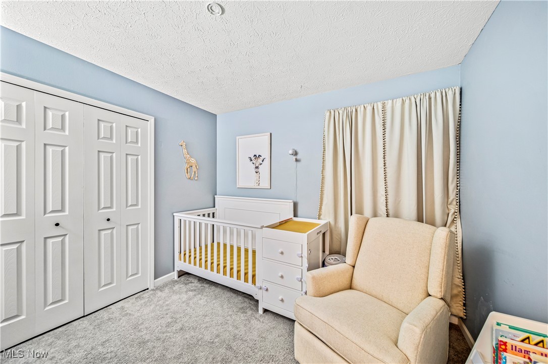 2959 Reeves Road Willoughby, OH 44094 - Photo 14 of 32 Carpeted bedroom featuring a textured ceiling, a nursery area, and a closet