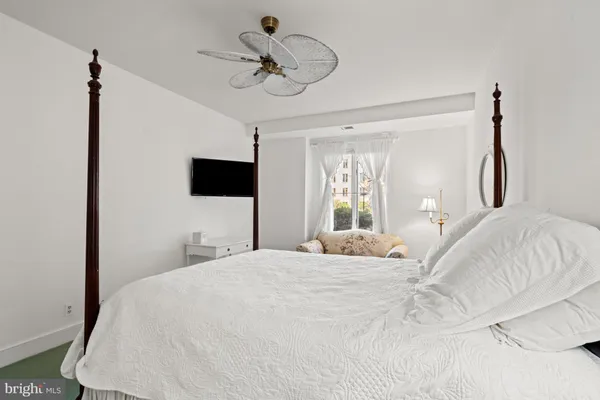 a bedroom with a bed and flat tv screen on the dresser